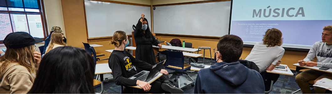 A teacher talks in the center of a group of students
