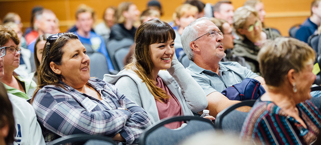 A family watches a sample class at an MSU Friday visit day.