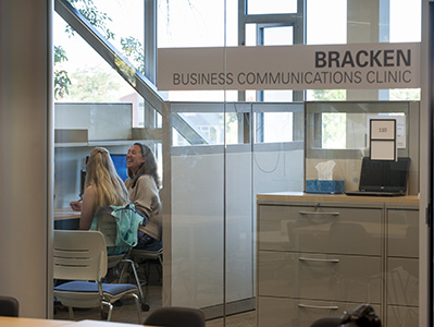 A communications coach works with a student on their writing assignment