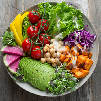 picture of a salad with lettuce, avocado, chickpeas, cabbage, and cherry tomatoes