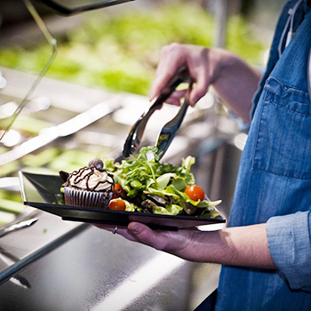 person serving food on a plate 