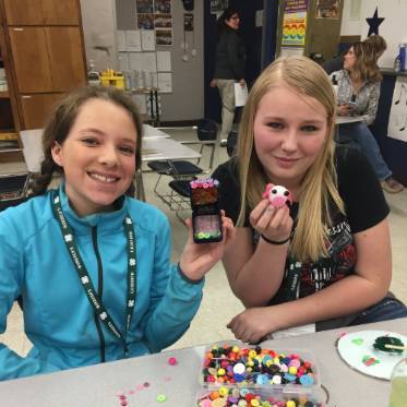 two girls smiling with their craft. 