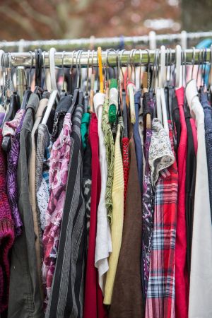 a wide variety of shirts hang on a clothing rack