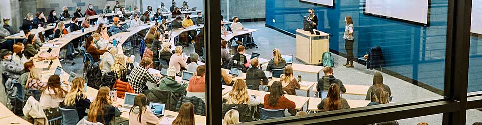 Students and instructors in a dual-content classroom viewed from an outside window