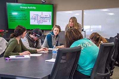 Group of people working on project in a classroom.