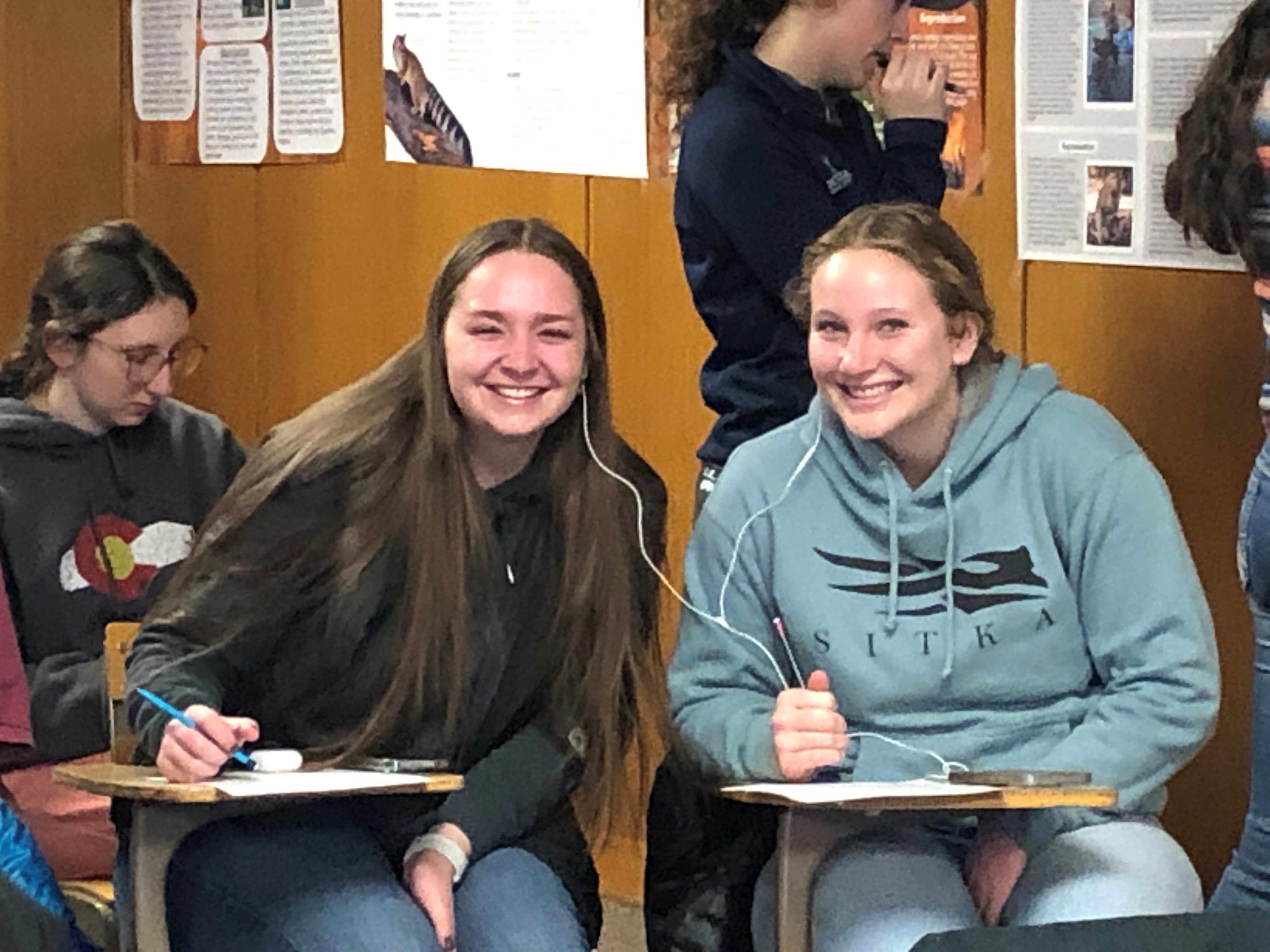 Kelsey and Denali listening to a classmates' podcast.