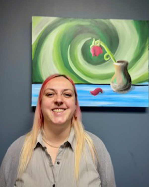 A person wearing a red and black long sleeved shirt and a necklace