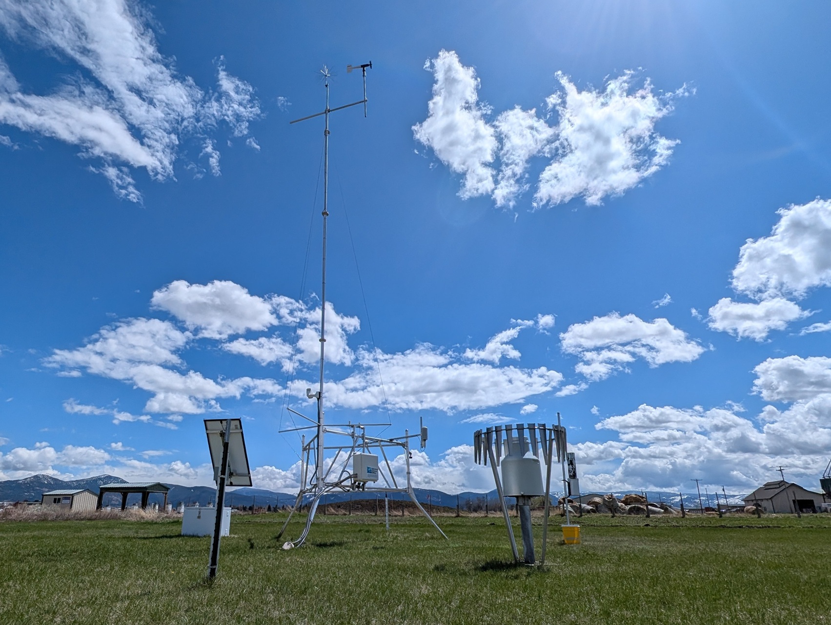 A tower with mutliple weather sensors stands against a blue sky