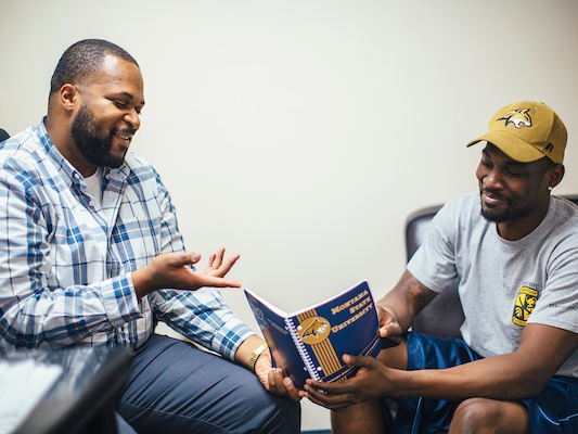 two men discussing a magazine