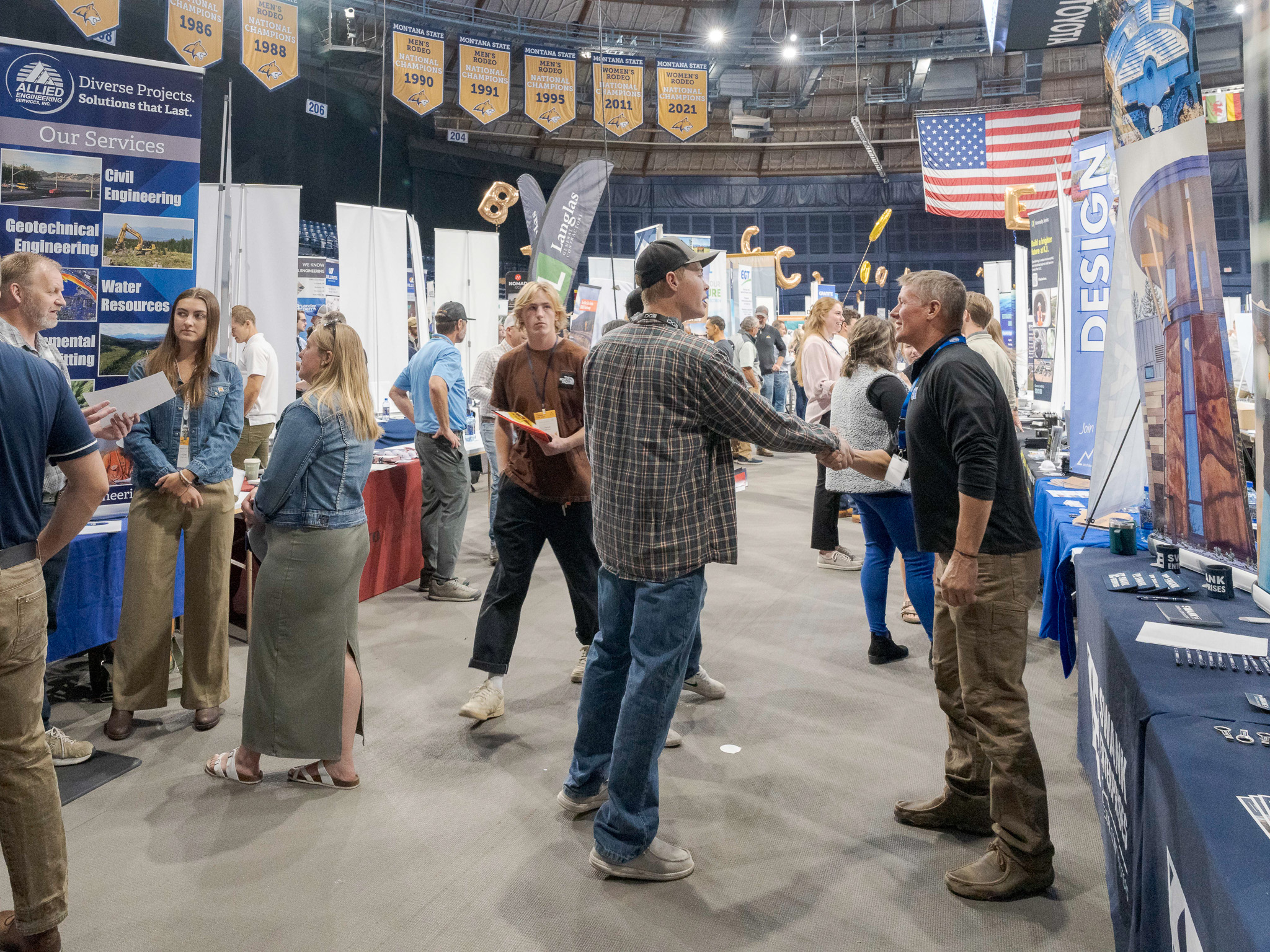 A large room filled with popup booths where people are talking to each other